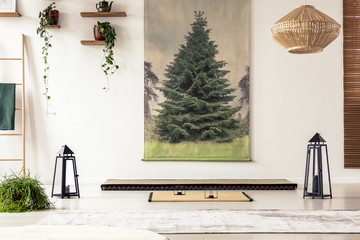 Obraz premium Tree painting on the wall, lamps, plants, tatami mat and mattress in a Japanese room interior
