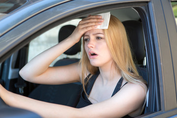 Woman being hot during a heat wave in car 
