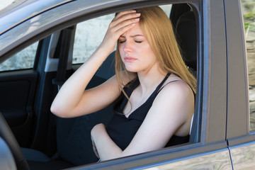 Obraz na płótnie Canvas young female driver with headache in a car