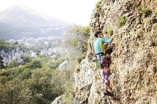 Woman rock climber. Rock climber climbs on a rocky wall. Woman makes hard move.