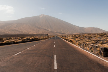 Road to El Teide volcano peak. Travel by car. Volcanic fields on the volcano. Landscape with road...