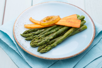 Fried asparagus with broccoli and lemon and carrot.