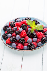 Fresh raspberries in a plate on a  vintage background.