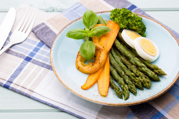 Fried asparagus with broccoli and lemon and carrot.