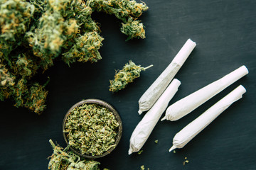Macro shot of cannabis joint of marijuana with trichomes and crushed weed in a grinder