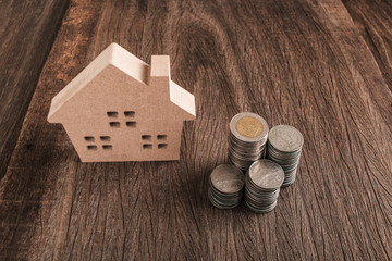 Rising stacks of coins and a house in the background
