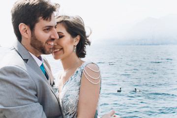 Bride leans to groom tender standing before the sea