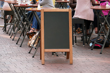 blank blackboard advertising sign or customer stopper at sidewalk cafe