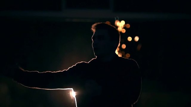 A man changes his legs in a jump, the lights of the night city, slow-motion