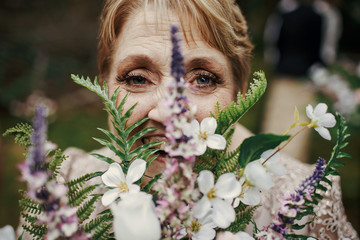 Obraz premium Bride's mother holds bouquet of lavander before her face