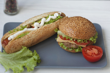 Hot dogs and hamburgers on the plate on wooden background. Street food. bistro Cafe