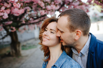 Fototapeta premium couple in love in a blooming Apple orchard lying on the blanket