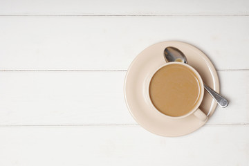 top view of cup of coffee with milk or flat white on wooden background with copy space