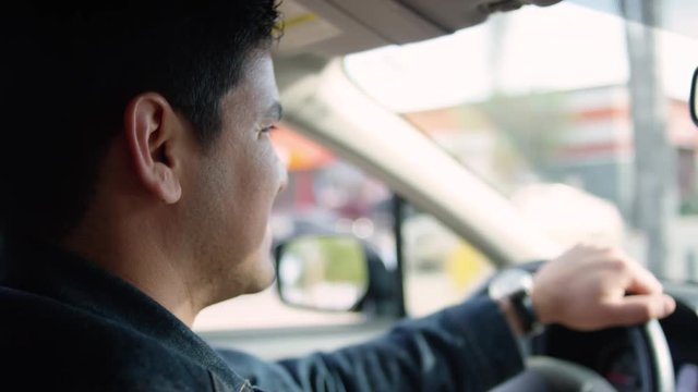 Happy Man Drives, He Smiles At Passenger And Then Keeps His Eye On Road In Los Angeles, CA (Slow Motion)