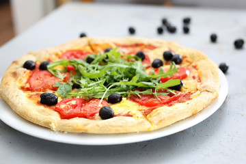 Pizza z mozzarellą i pomidorami. Pizza z pomidorami, czarnymi oliwkami, rukolą.
