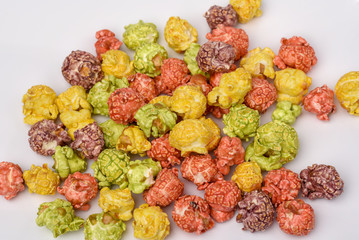 A pile of colorful caramel popcorn, still life for a holiday with colorful popcorn on white wooden table.