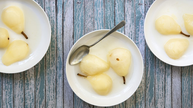 Cooked pear halves in dessert bowls.
