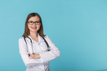 Smiling medical doctor woman with stethoscope over blue background with copy space