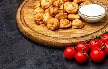 Dumplings stuffed with meat sprinkled with fresh herbs , top view, black background