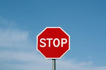Stop sign against cloudy sky.