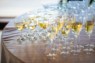 A lot of wine glasses with a cool delicious champagne or white wine at the bar. Alcohol background.