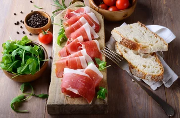 Fotobehang Dienblad met rauwe ham, Italiaanse prosciutto crudo © fabiomax