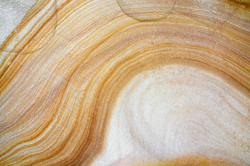 Close-up of natural sandstone texture with yellow and white layered wave pattern - 206963495