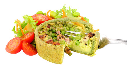 Pea and pancetta filled savoury quiche with fresh simple salad isolated on a white background