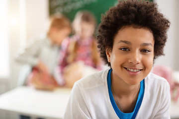 School pupil. Portrait of a joyful nice schoolboy smiling while looking at you