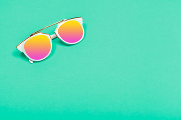 Top view. Fashion sunglasses on pastel background