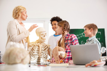 New information. Pleasant curious children being attentive while listening to their biology teacher