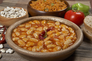 Dried beans,white beans in tomato sauce in bowl closeup. horizontal
