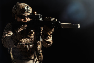 Special forces soldier with rifle on dark background