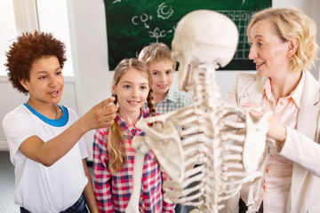 What is this. Nice smart boy pointing at the skeleton while asking his teacher about it