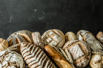 Bakery - rustic crusty loaves of bread and buns on black
