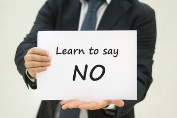 man in suit showing text Learn to say NO