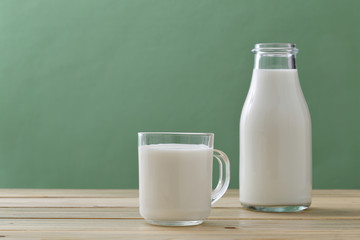 latte in bicchiere  e bottiglia di vetro su tavolo di cucina