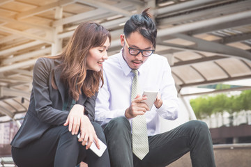 Business team working at city, looking a mobile phone