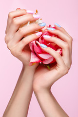 Beautiful pink and blue manicure with crystals on female hand. Close-up. Picture taken in the studio