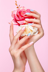 Beautiful pink and blue manicure with crystals on female hand. Close-up. Picture taken in the studio