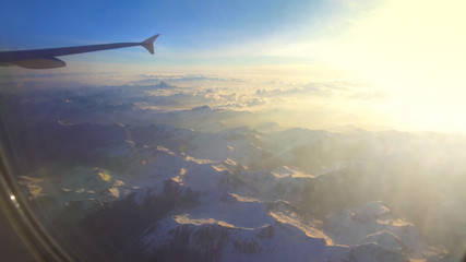 Fototapeta na wymiar Snow-capped mountain range peaks viewed from airplane, winter resort, holidays