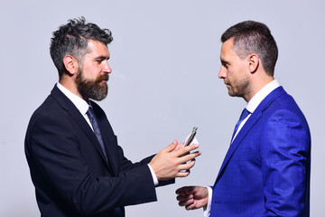 Businessmen with busy faces in formal suits on grey background.