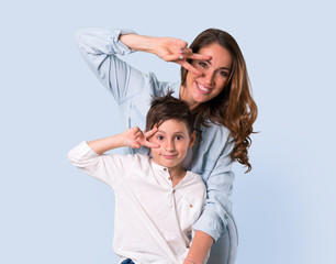 Mother and daughter makes funny and crazy face emotion on blue background