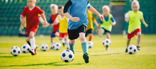 Voetbal voetbal training voor kinderen. Kinderen voetbal training. Kinderen rennen en schoppen tegen voetballen. Jonge jongens verbeteren voetbalvaardigheden