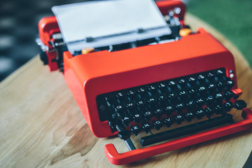 Bright red typewriter with paper sheet inserted