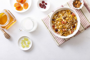 Muesli served with milk, grapes, almonds, dried apricots and dried cranberries