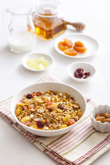 Muesli served with milk, grapes, almonds, dried apricots and dried cranberries
