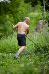 Strong man mowing the lawn