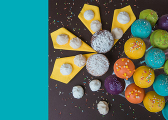 Top view of cake pops on a dark brown background, decorated for birthday  celebration, with bright blue copy space. Selective focus
