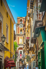 Fototapeta na wymiar Narrow street with Duomo steeple in old town Sorrento